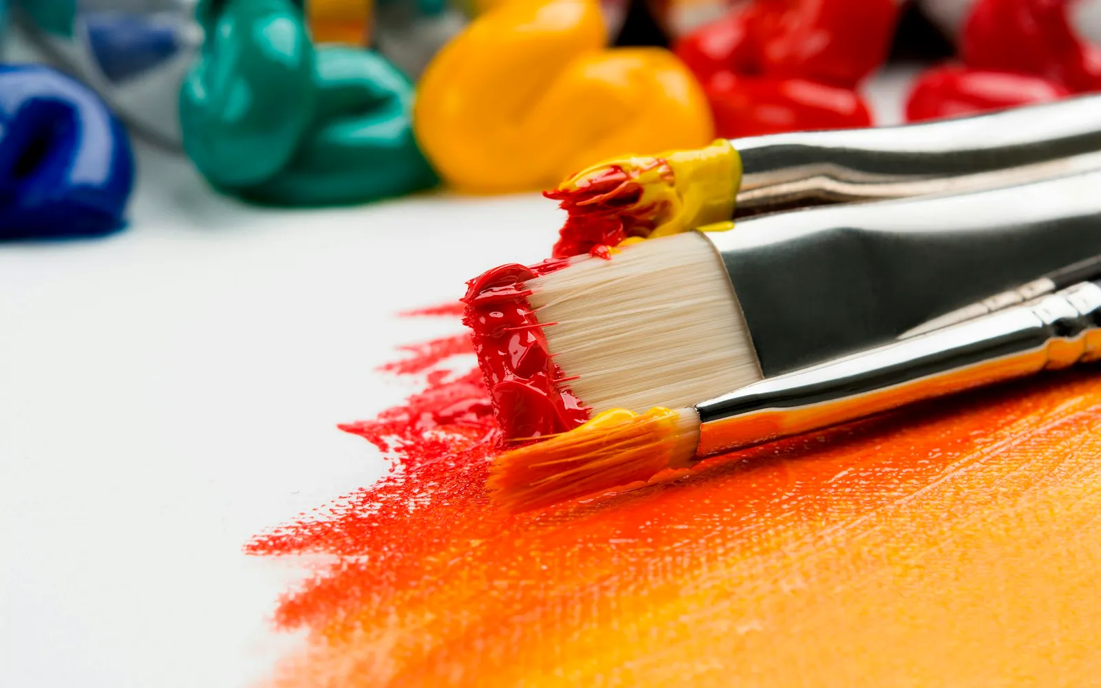 Artist's desk covered in sketches, brushes and colour swatches